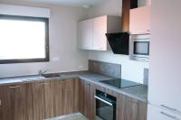 a kitchen with wooden cabinets and a sink and a microwave at L&#39;orée de la Forêt in Desvres