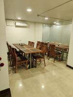 Un comedor con mesas y sillas de madera. en Rosemallow Hotel New Delhi, en Nueva Delhi