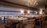 a dining room with tables and chairs and a chandelier at Alva Valley Hotel in Oliveira do Hospital