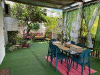 une terrasse avec une table, des chaises et des plantes dans l&#39;établissement Ptite case Fantaisie, à Saint-André
