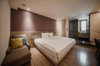 a bedroom with a large bed and a couch at Hub Hotel Kaohsiung Yawan Branch in Kaohsiung