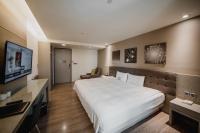 a hotel room with a large bed and a flat screen tv at Hub Hotel Kaohsiung Yawan Branch in Kaohsiung