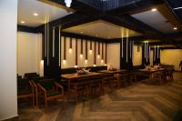 a dining room with wooden tables and chairs at Hotel Pavitra in Pūrnia