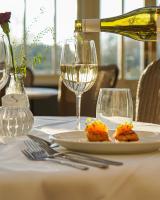 a bottle of white wine pouring into a plate of food at Owston Hall Hotel in Doncaster