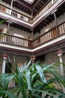 a building with wooden balconies and a plant in the foreground at Hotel Mercader de Sedas by Maxi Hoteles in Granada