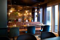ein Restaurant mit zwei Tischen und Stühlen und einem Fenster in der Unterkunft Home Hotel Tollboden in Drammen