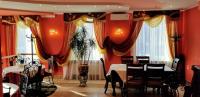 a dining room with red walls and curtains at Едем in Skhidnitsa