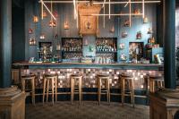 a bar with stools in a room at Hôtel France et Chateaubriand in Saint Malo