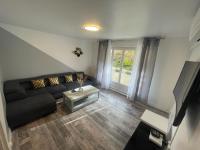 a living room with a black couch and a table at Prestation hôtellerie Chalon-sur-Saône in Chalon-sur-Saône