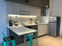 Una cocina con encimera blanca y refrigerador. en Departamento Estudio, centrico, en Temuco