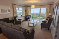 Una sala de estar con un sofá y sillas y un televisor. en Gurranebawn, Cahersiveen, en Cahersiveen