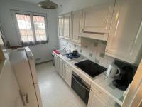 a kitchen with white cabinets and a sink and a refrigerator at Prestation hôtellerie Chalon-sur-Saône in Chalon-sur-Saône