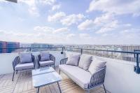 a balcony with two chairs and a couch on a roof at Grand appartement avec belle vue Paris in Rueil-Malmaison