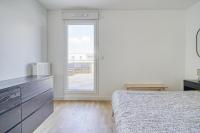 a white bedroom with a bed and a window at Grand appartement avec belle vue Paris in Rueil-Malmaison