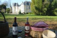 two bottles of wine and glasses on a table with a house at holiday home, Grayan-et-l&#39;Hôpital in Grayan-et-lʼHôpital