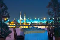 a dinner table with a view of a mosque at night at Mosaic Hotel Old City -Special Category in Istanbul