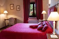 a bedroom with a red bed with pillows and a window at Château de Ribourdin in Chevannes