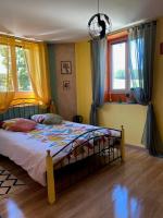 a bedroom with a bed and two windows at Le Moulin du Modon in Couffy