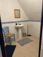 a bathroom with a sink and a blue chair at Le Moulin du Modon in Couffy