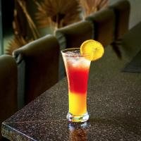 uma bebida sentada numa mesa com uma fatia de laranja em Vagator Downtown By VDP em Vagator