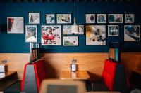 a restaurant with red chairs and pictures on the wall at Holiday Inn Express Belfast City by IHG in Belfast