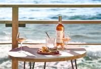 Una botella de vino y dos copas en una mesa en Hotel Plein Large, en Bandol