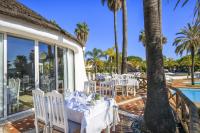 comedor con mesa y sillas junto a la piscina en Luxury 2 Bedroom Apartment with Private Garden, en Almancil