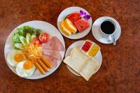 a table with two plates of food and a cup of coffee at Sipanya Guesthouse in Muang Phônsavan
