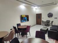 una sala de espera con mesas y sillas y un sofá en Passready Hotel and Suites Nnewi, en Nnewi