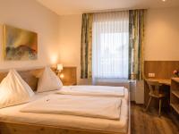 a bedroom with a large white bed in front of a window at Pension Ehrenfried - Hotel garni in Kindberg