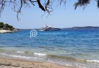 a boat in the water next to a beach at Villa Tranquility - Walk to the Beach with Infinity Pool in Porto Heli