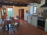 a kitchen with a table and a kitchen with a stove at La Chavoche in La Chapelle-de-Bragny