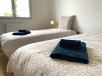 two beds with blue towels sitting on top of them at La belle des champs in Luzillé