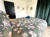 a bedroom with a bed with a flowered blanket at La belle des champs in Luzillé