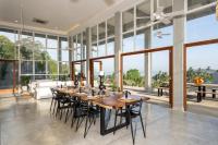 duża jadalnia z długim stołem i krzesłami w obiekcie The Nine Mirissa w mieście Mirissa