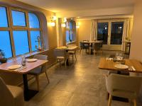 Un restaurante con mesas, sillas y ventanas. en C La Suite, en Pomponne