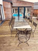 a table and chairs on a deck with a pool at Le Loft in Stoumont