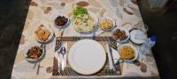 a table with plates and bowls of food on it at Leel’s Safari Cottage in Udawalawe
