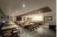 a restaurant with couches and tables and chairs at Hotel New Blue Earth in Srīkākulam