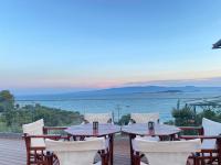 una mesa y sillas en una terraza con vistas al agua en Hotel Filoxenia, en Ouranoupoli