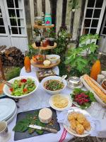 a table with plates and bowls of food on it at Gîtes du Manoir de la Porte in Les Authieux-sur-Calonne