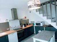 a kitchen with green cabinets and a table in a room at Loc5c in Noirmoutier-en-l&#39;lle