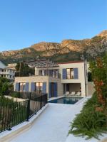 ein Haus mit einem Pool vor einem Berg in der Unterkunft Belsize Villas in Budva