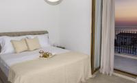 ein Schlafzimmer mit einem Bett und einem großen Fenster in der Unterkunft Belsize Villas in Budva