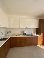 eine Küche mit weißen Schränken und einer Kaffeemaschine auf der Theke in der Unterkunft Belsize Villas in Budva