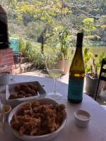 a bottle of wine and a plate of food and a glass at Hotel Fazenda Upã Moña in Vassouras