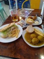 une table avec deux assiettes de nourriture et un sandwich et des frites dans l'établissement Ronda Centro - Relax, à Ronda