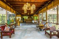Una habitación grande con sillas, mesas y ventanas. en Hacienda Herrera Tambopata, en Puerto Maldonado
