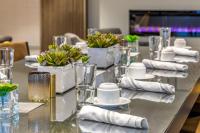 a long table with glasses and napkins on it at Cambria Hotel Rehoboth Beach in Rehoboth Beach