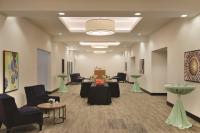 a waiting room with couches and tables and chairs at Hyatt Place Chicago O'Hare Airport in Rosemont